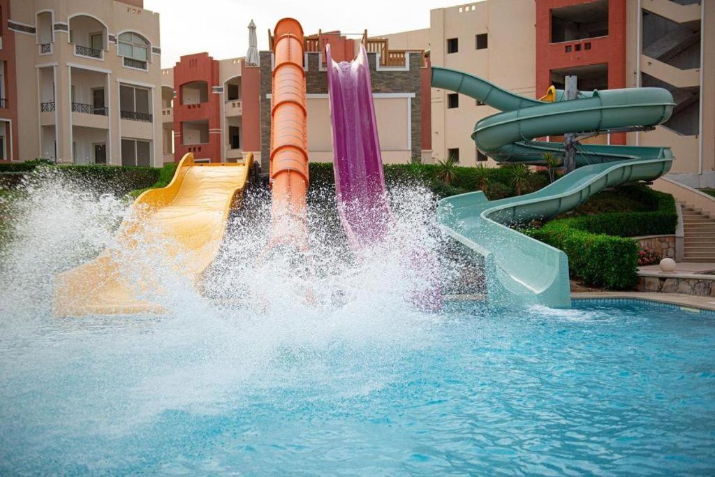 un tobogán de agua en una piscina de un complejo turístico en Oyster Bay Beach Suites, en Marsa Alam
