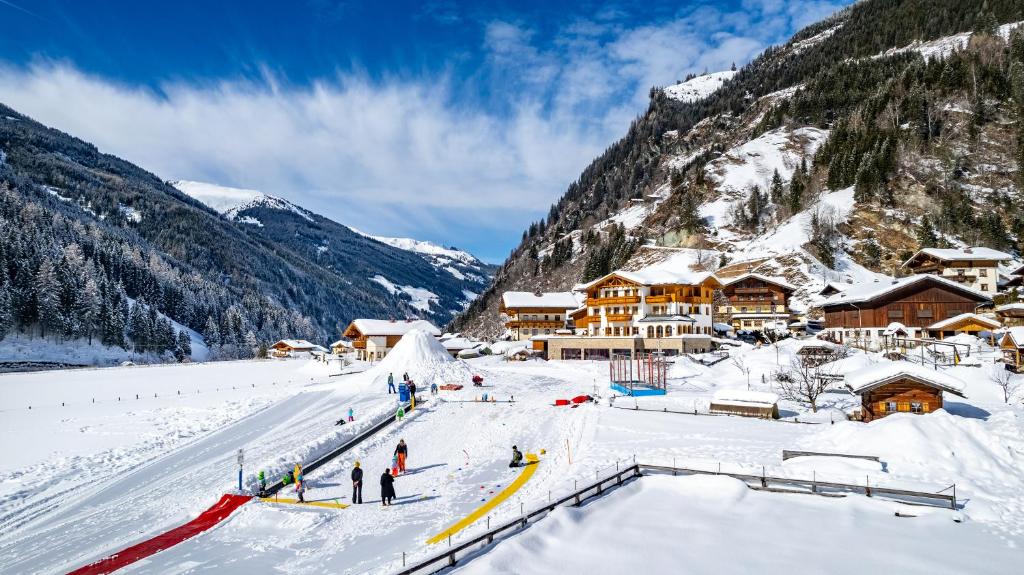 a group of people in the snow at a ski lodge at Familienhotel Oberkarteis in Hüttschlag