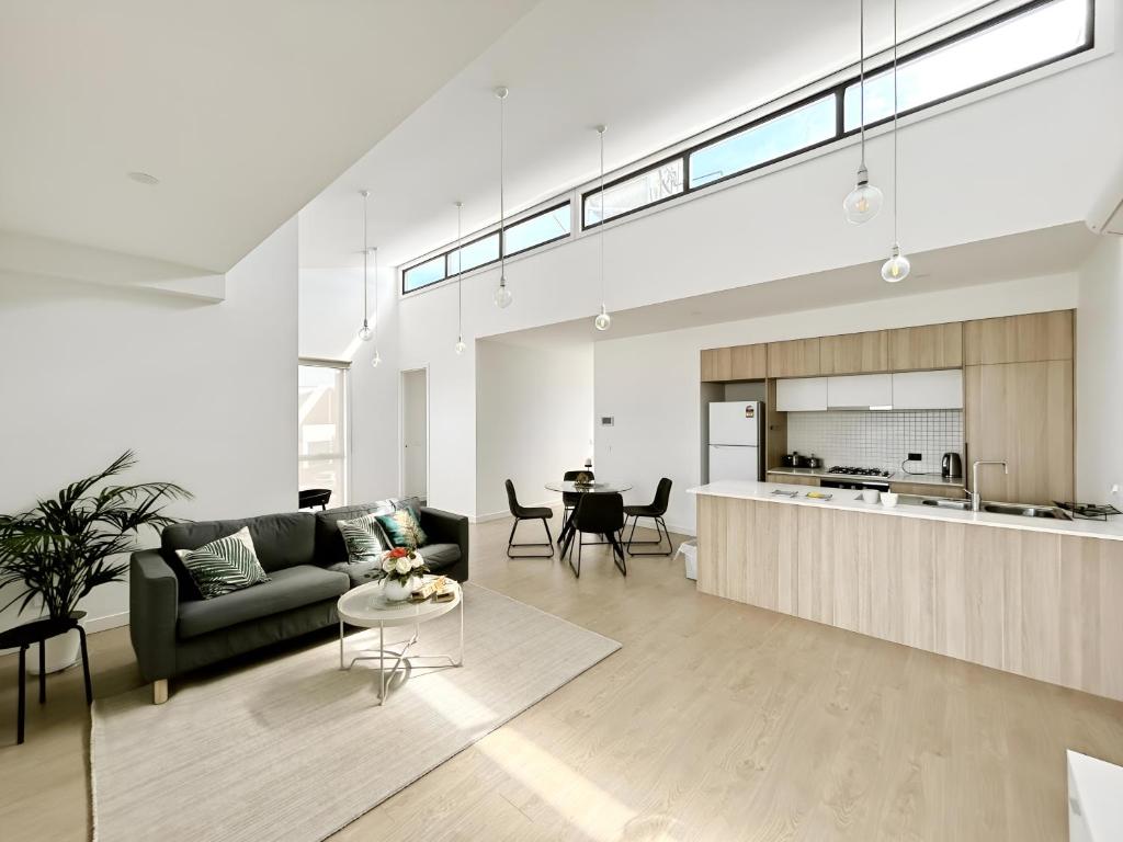库克角Skyline Loft I HERstay in Point Cook的客厅里有一张沙发和一张桌子。
