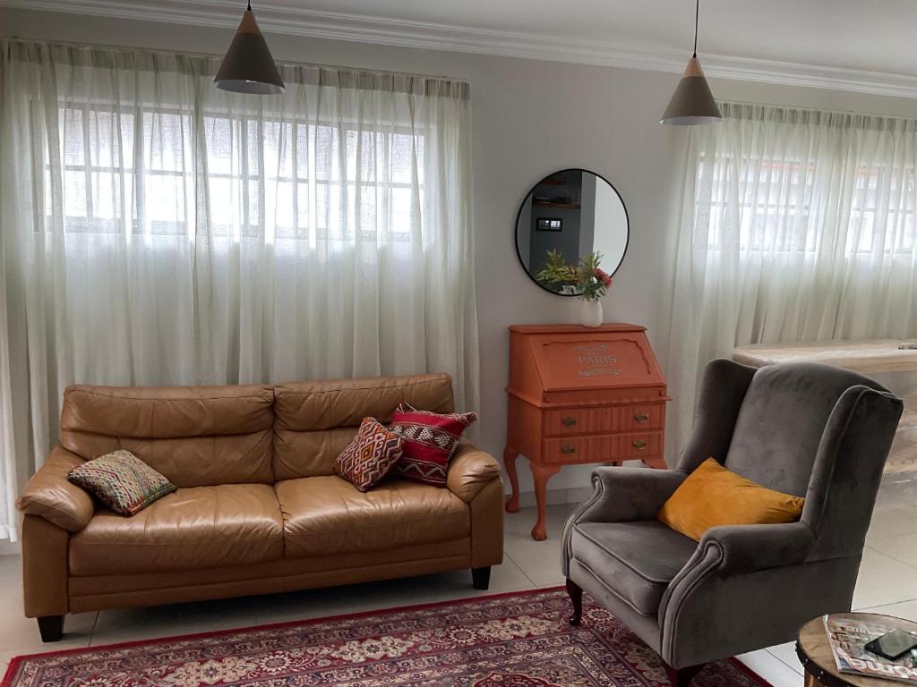a living room with a couch and a chair at Ginnys Place in Gaborone