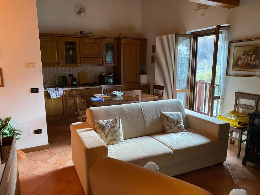 a living room with a couch and a kitchen at Mansarda Residenza Giada in Pila