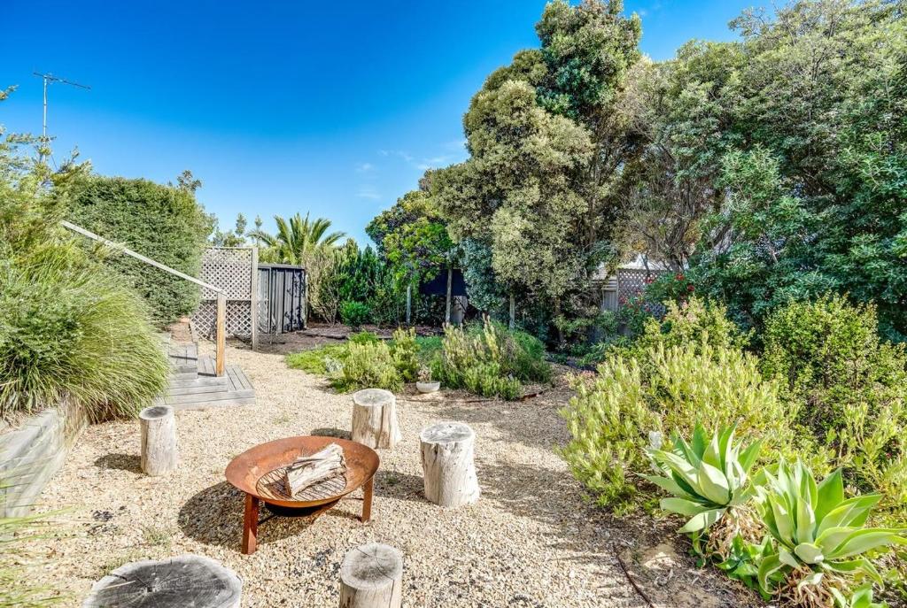 Goolwa SouthDelight On Downer - Coastal Family Escape的花园,花园内有桌子和一些植物和树木