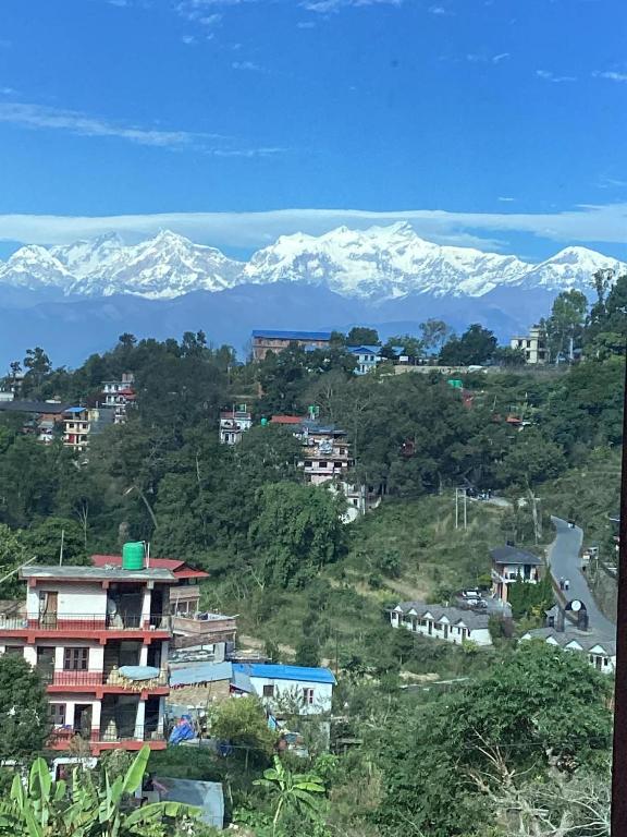 a city with snow capped mountains in the background at Bandipur Samira Hotel & Homestay - your comfort in heart of Bandipur in Bandipur