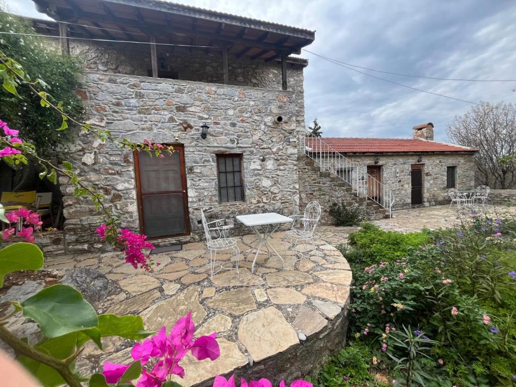 una casa in pietra con tavolo e sedie su un patio di Zeytin a Datça