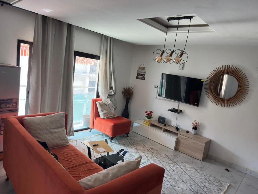 Una sala de estar con un sofá y un televisor. en Résidence Karima, en Abiyán