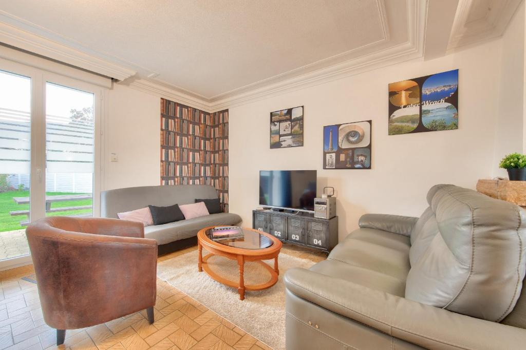 a living room with a couch and a tv at Maison pour 6 avec grand jardin - proche centre in Plouguerneau