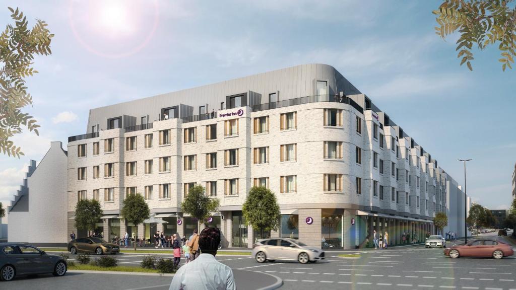 a building with cars parked in a parking lot at Premier Inn Duisburg City Altstadt in Duisburg