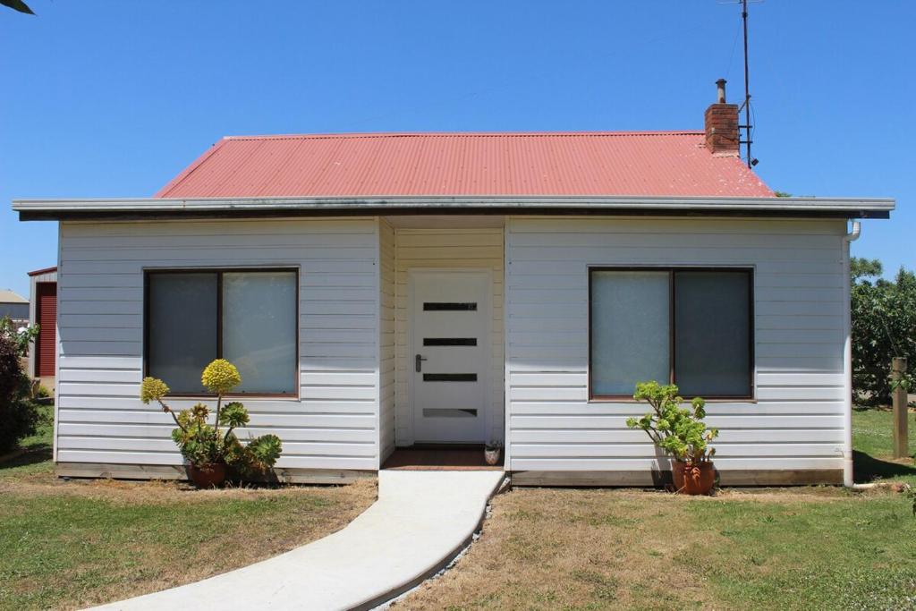een klein wit huis met een rood dak bij Nonna's Cottage 
