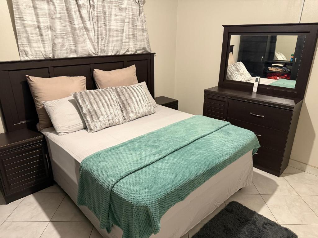 a bedroom with a bed with a large mirror at Namasiku 's Self Catering in Khomas Region