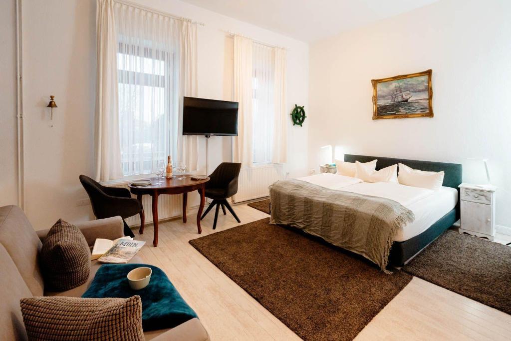 Kapitaenshaus-Lassen-Zimmer-Santa-Maria في فيسترلاند: غرفة نوم مع سرير وغرفة معيشة