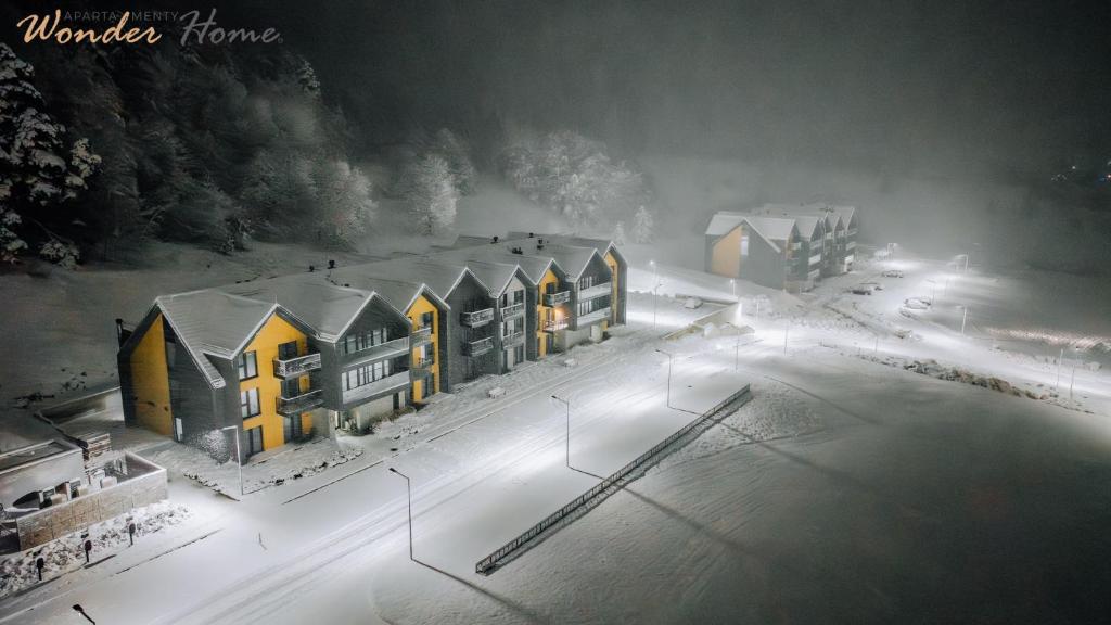 a rendering of a building in the snow at night at Wonder Hill - apartamenty z klimatyzacją, balkonami lub trasami in Sosnówka