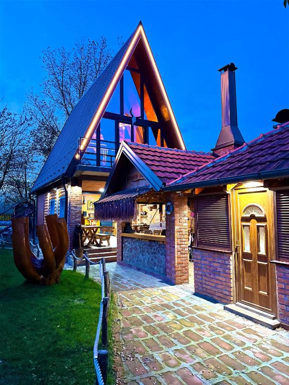 a house with a large building with a brick driveway at Beaver lodge - Dabrova Koliba in Bijeljina