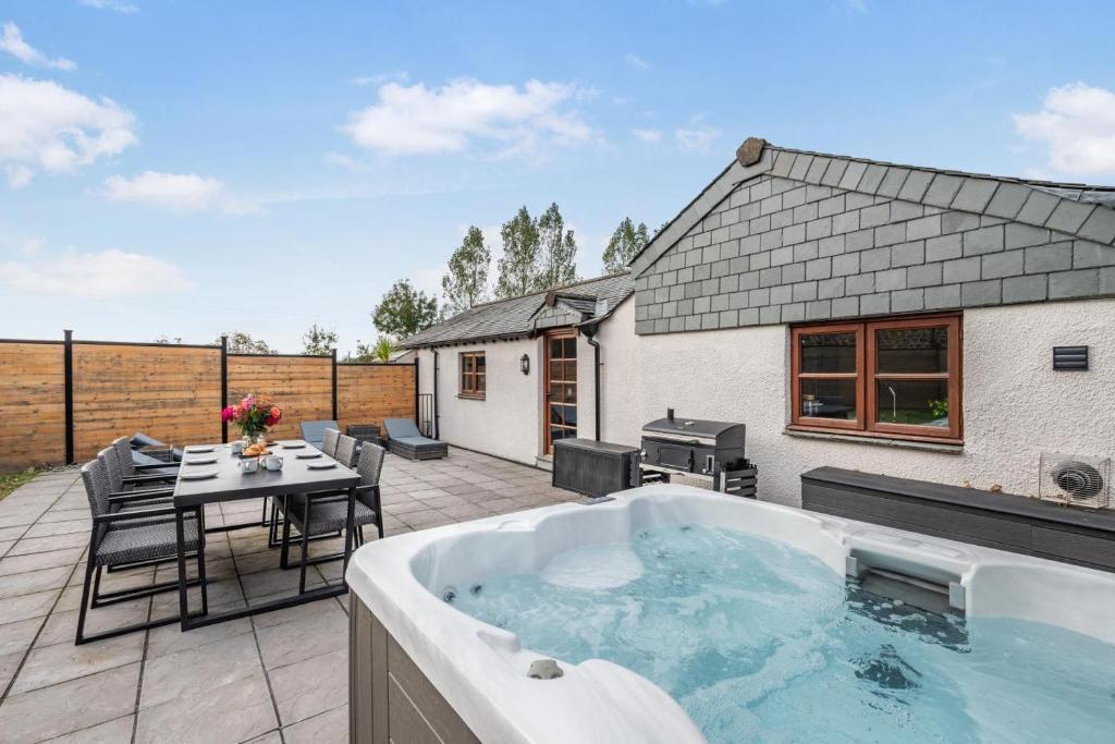 een hot tub op een patio met een tafel en stoelen bij 2 Bed in Pancrasweek oc-o30445 in Pancrasweek