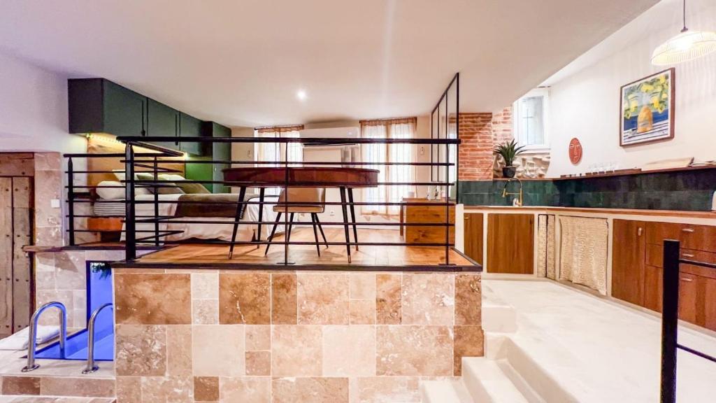 佩皮尼昂Amagat Loft Piscine et Hammam的客厅里有一张桌子和一个厨房