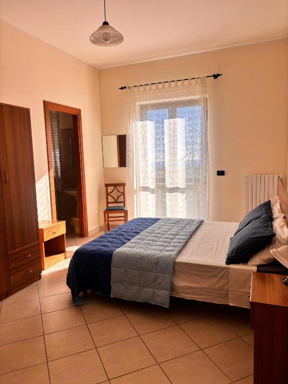 a bedroom with a bed and a large window at Nonno Pierino affittacamere in Civitella Casanova