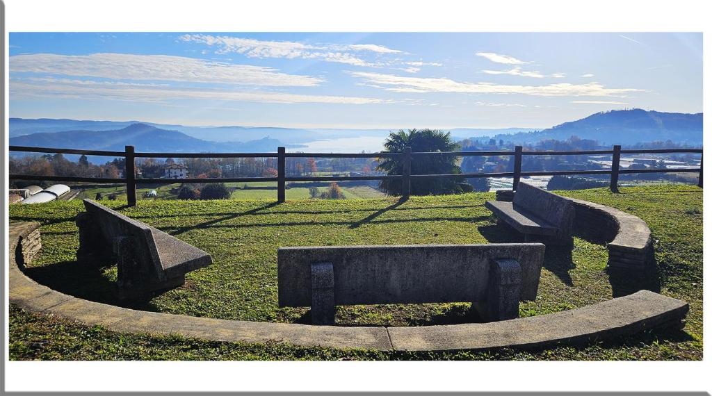 Romantic Retreat On The Lake في Nebbiuno: مجموعة من المقاعد الحجرية جالسة على العشب