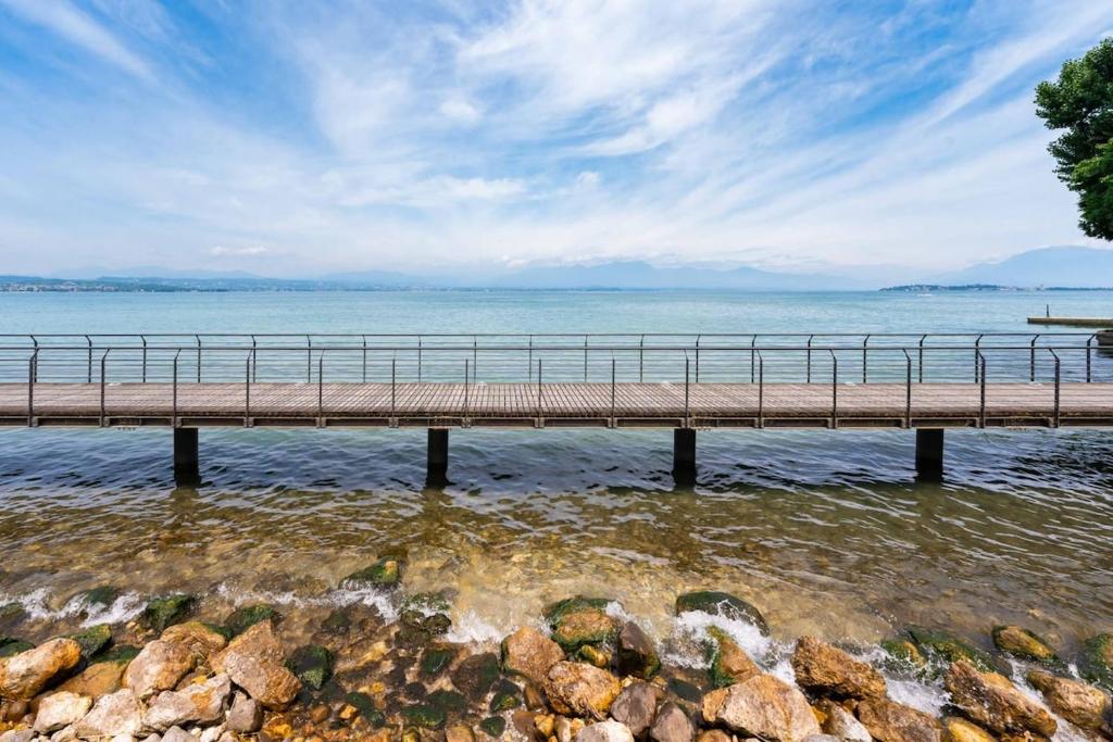 a bridge over a body of water with rocks at Villa Aquarium in Desenzano del Garda