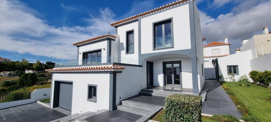 a white house with a view of a yard at Villa Lina in Lourinhã