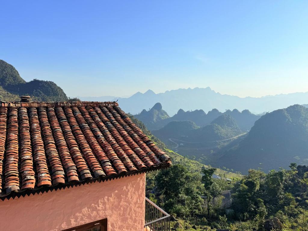 ein Dach eines Gebäudes mit Bergen im Hintergrund in der Unterkunft Ha Giang Aya Lodge by Localvietnam in Dồng Văn