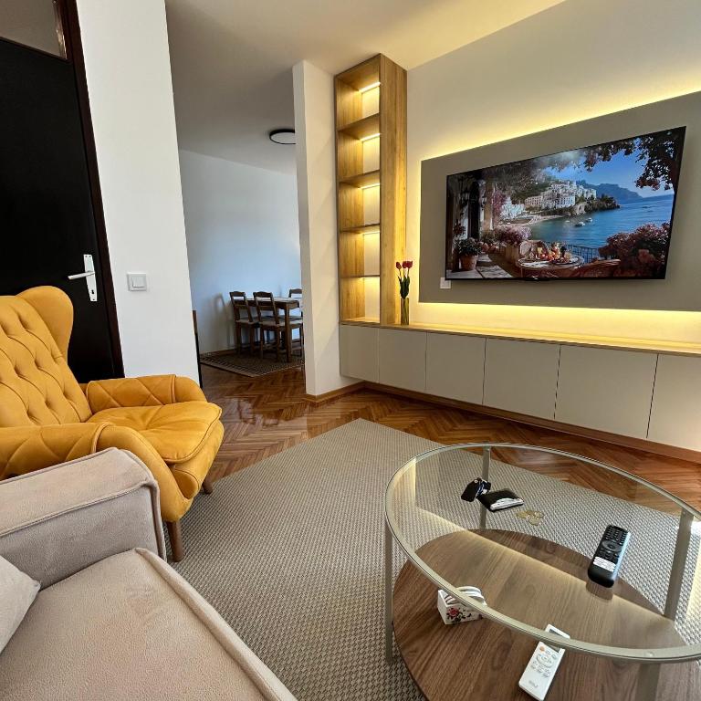 a living room with a tv and a glass coffee table at Stay In Bar in Bar