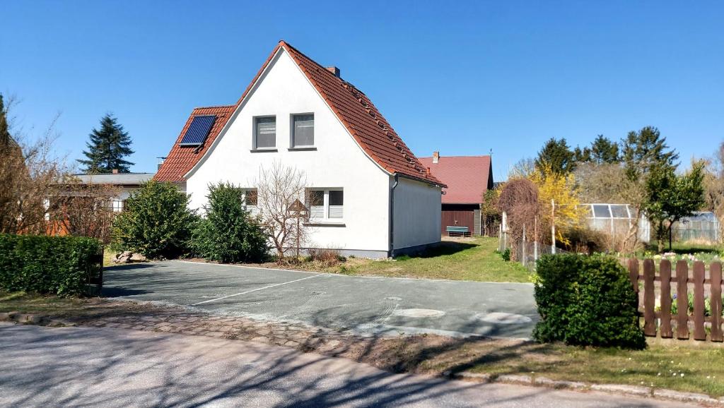 a white house with a fence and a driveway at Ferienhaus Nele - ein strandnahes, einfaches Haus in Breege
