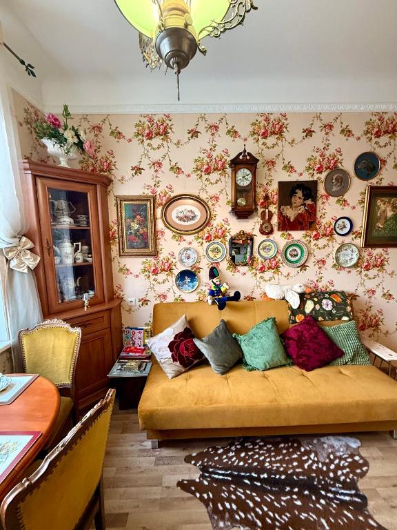 a living room with a couch and a wall filled with plates at Old Town Riverside Antique Gallery Self Check-In in Klaipėda
