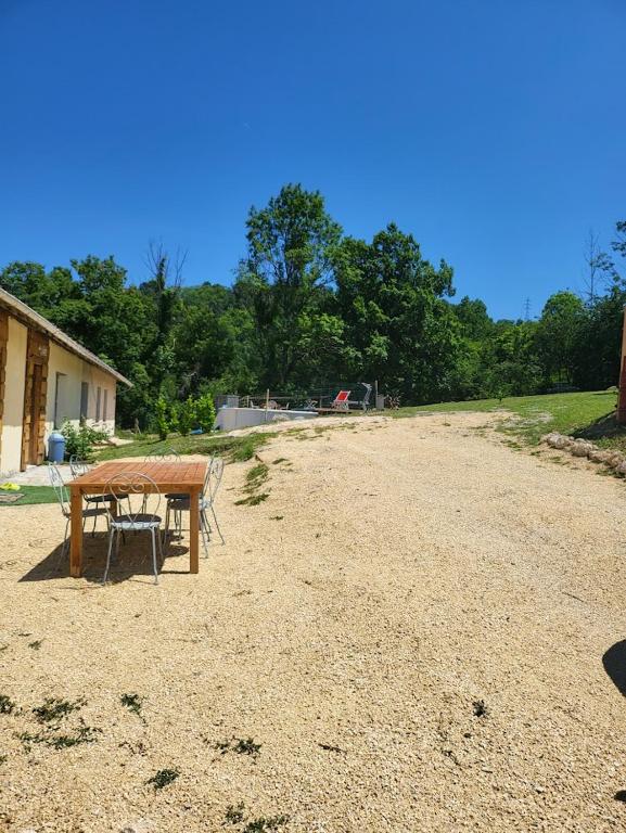 a picnic table and chairs on a dirt field at La maison de la Motte in La Motte-Fanjas