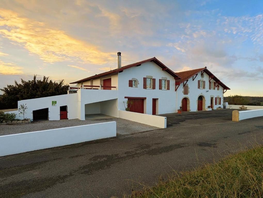 a white house with a sunset in the background at Loustaou in Bidache
