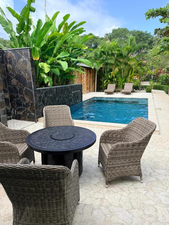 a patio with a table and chairs and a pool at Casa Adam in Pochote