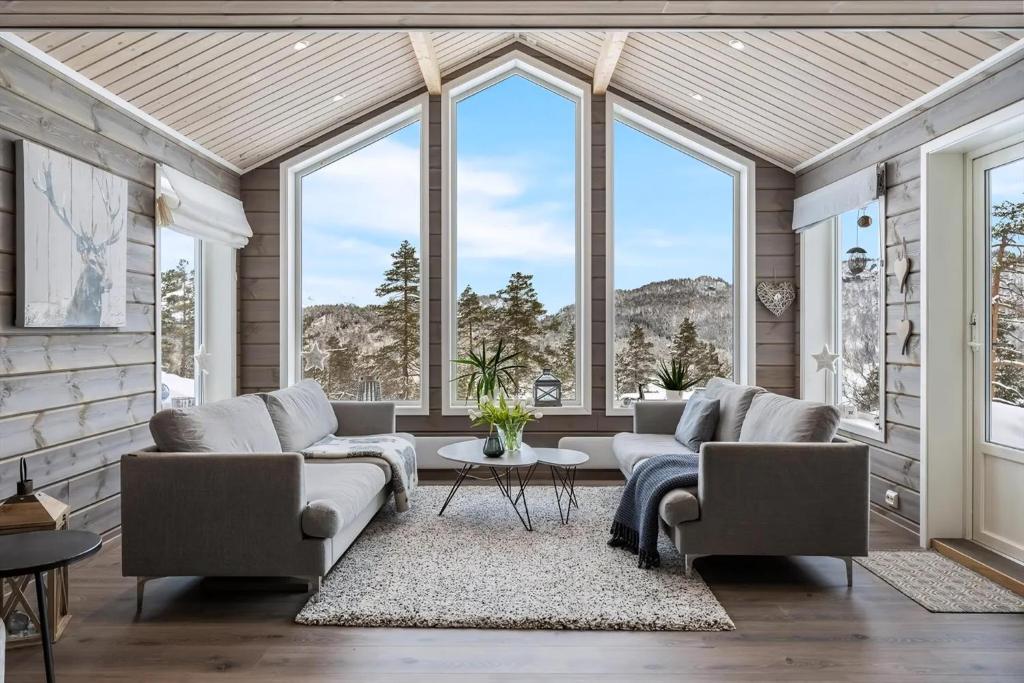 sala de estar con 2 sofás y ventanas grandes en Modern Cabin Near Maldalsvatnet And Reinsnuten, en Saudasjøen