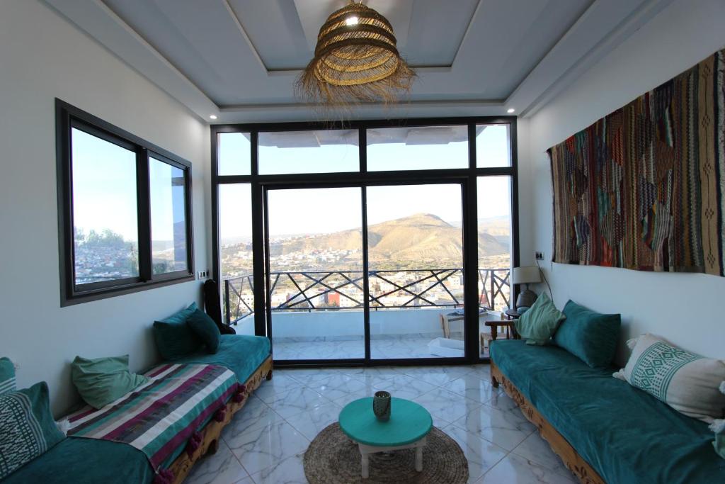 un soggiorno con 2 divani verdi e un tavolo di Agadir Funky Chill Guesthouse Surf, Horse, Music adventures ad Aourir