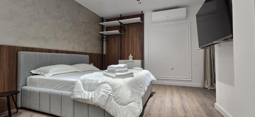 una camera da letto con un letto e un tavolo con sopra degli asciugamani di STAY-FIVE Cozy Modern Studios in Tirana Center - Brand New a Tirana