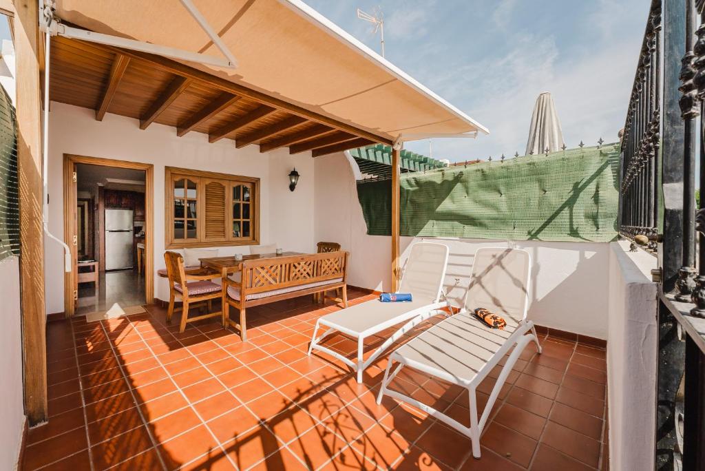 een terras met twee stoelen en een tafel op een balkon bij Playa Chica apartment in Puerto del Carmen