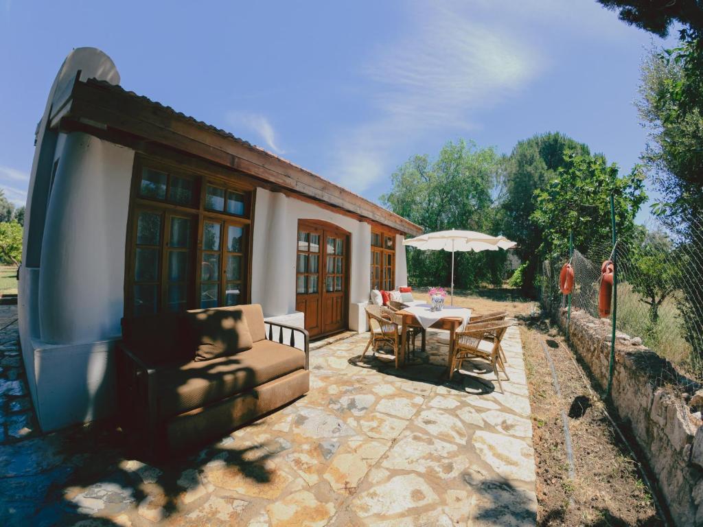 un patio di una casa con tavolo e ombrellone di Bitez Village Room a Bodrum City