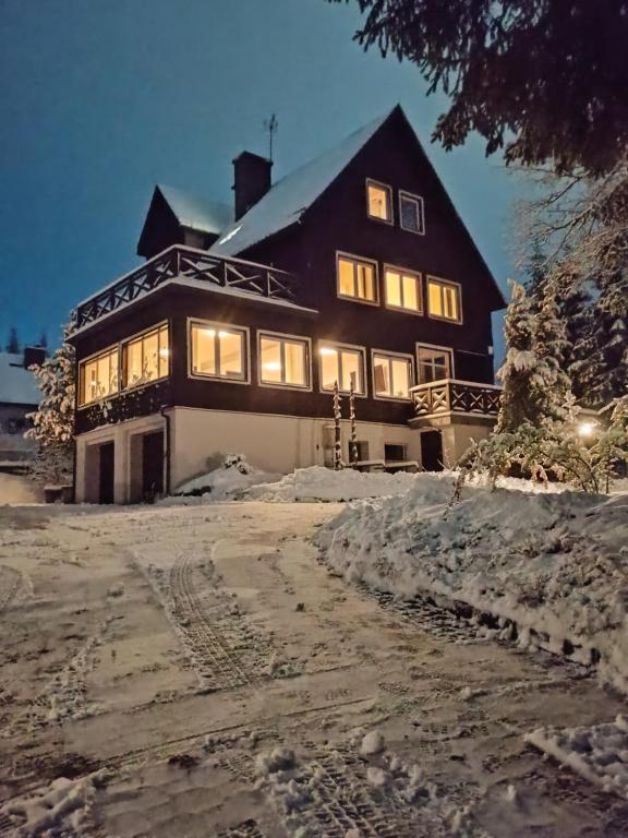 a large black and white house in the snow at Willa Cieszynianka in Wisła