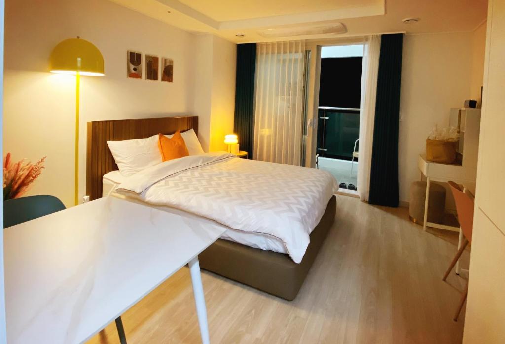 束草市스테이 윤 써밋베이1009的一间卧室配有一张带书桌的床和窗户。