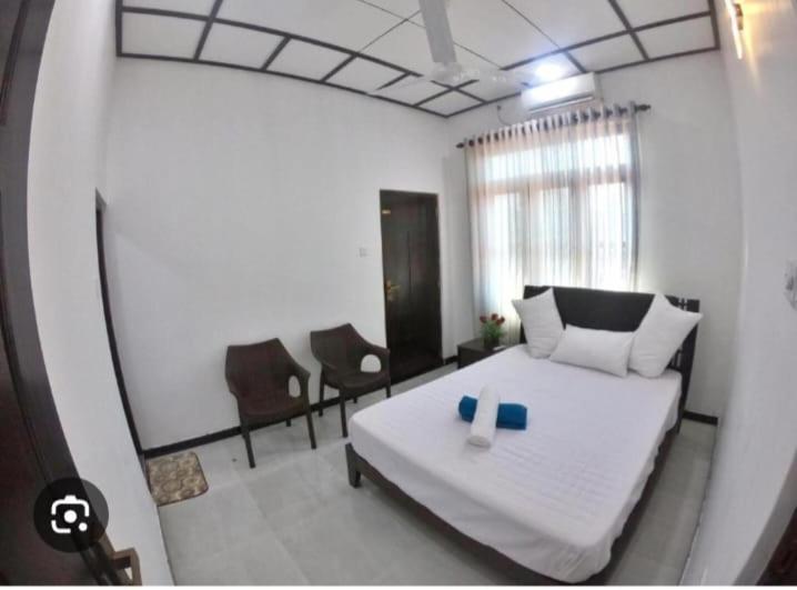 ein Schlafzimmer mit einem Bett mit zwei blauen Kerzen darauf in der Unterkunft madurasinghe villa in Anuradhapura