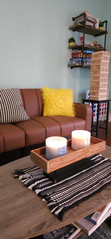 ein Wohnzimmer mit einem braunen Sofa und einem Tisch in der Unterkunft Vintage Eastside Beltline Trail Apartment by Krog St Market with Free Parking in Atlanta