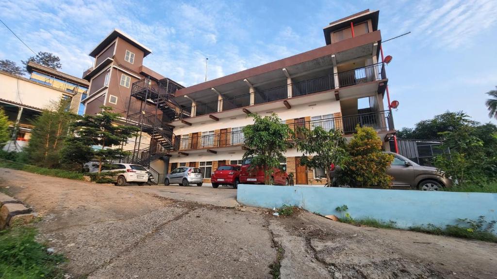 MeppādiにあるApple Tower Staysの前に車が駐車されている大きな建物