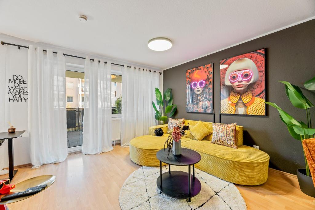 a living room with a yellow couch and a table at Goldstadt Fancy Apartment in Pforzheim