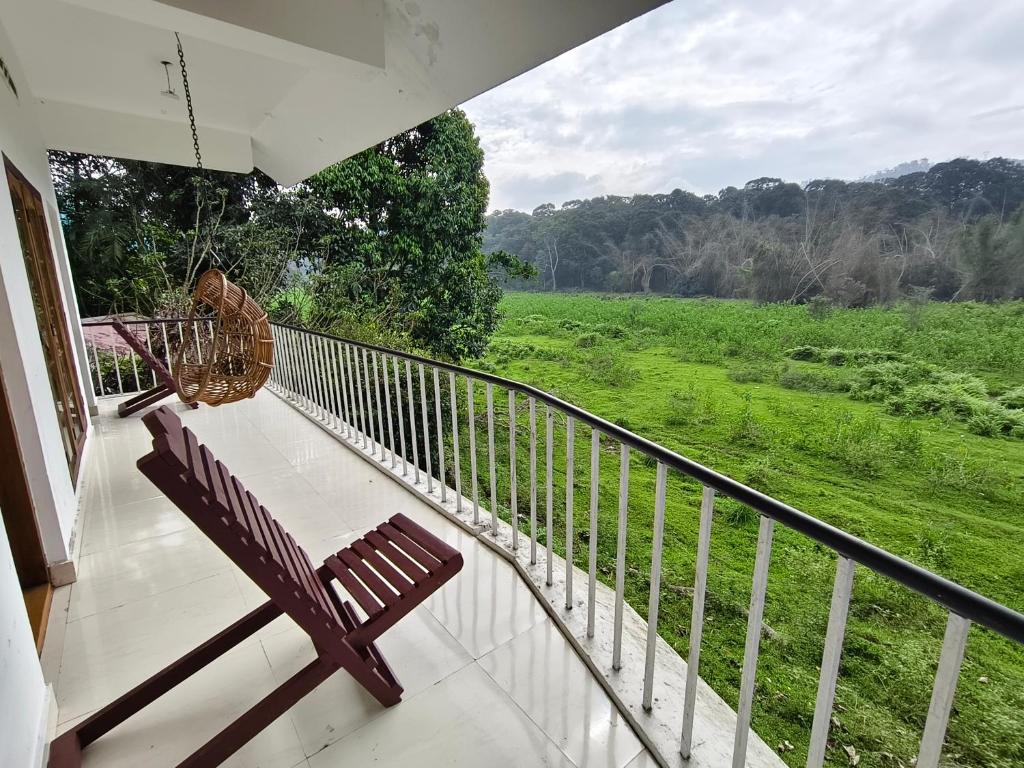 porche con banco y vistas al campo en Wild Forest Inn Thekkady, en Thekkady