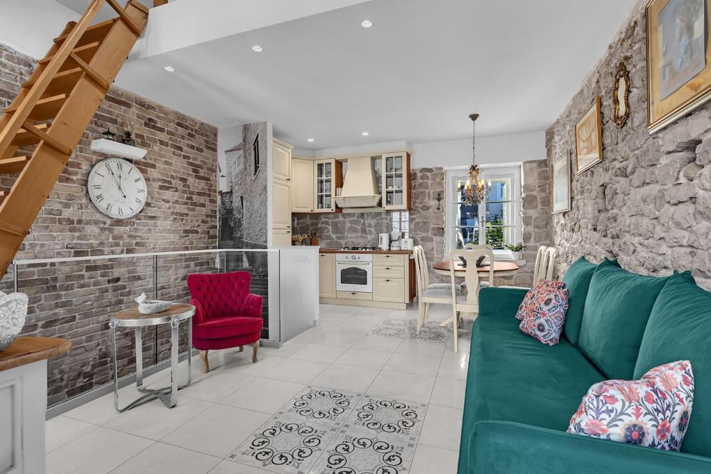 マカルスカにあるVilla Old Town Centre Makarska - Makarska Exklusivの緑のソファとレンガの壁が備わるリビングルーム