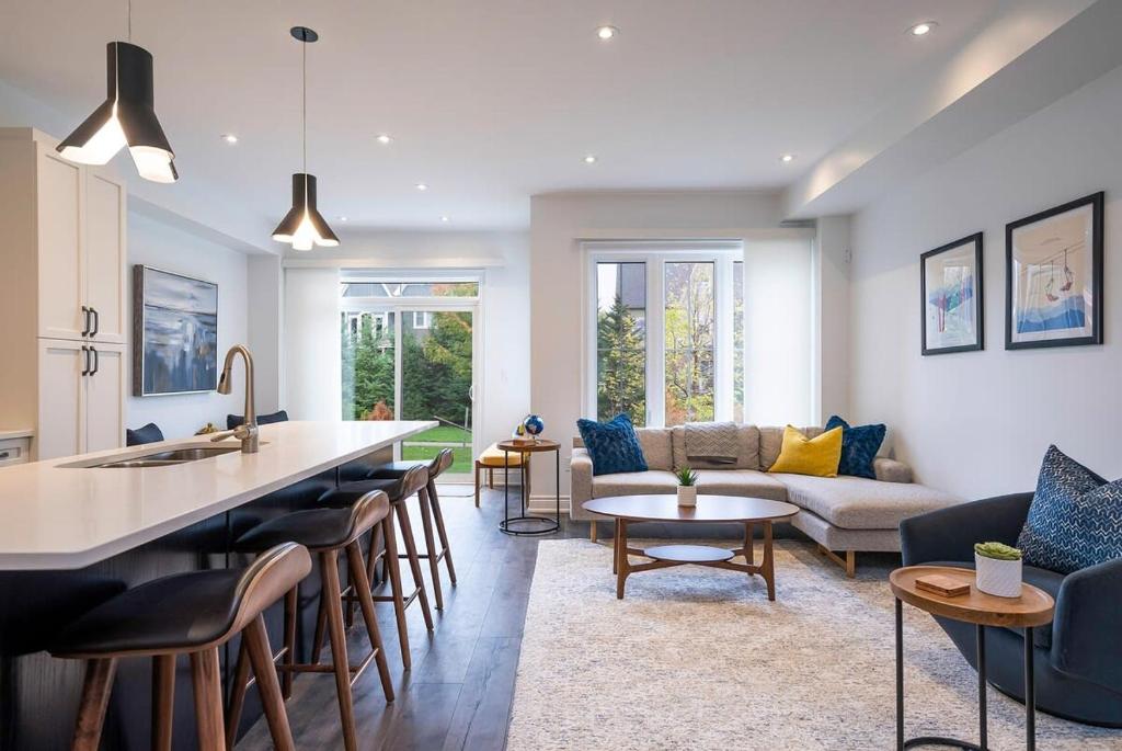 una cucina e un soggiorno con un divano e un tavolo di Blue Mountain Townhome - Patio Shuttle Trails a Collingwood