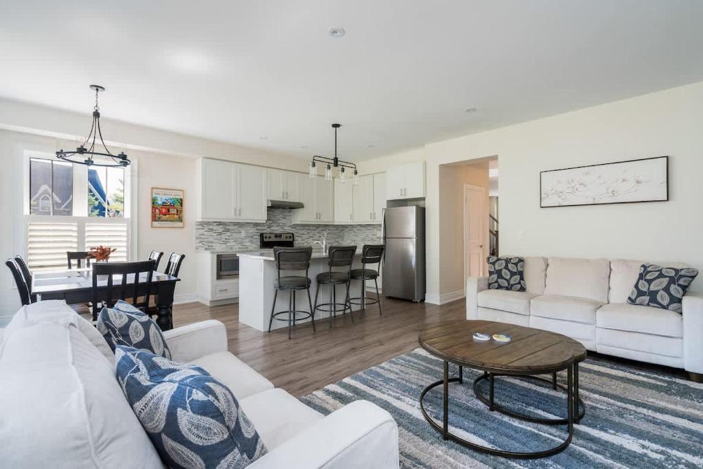 ein Wohnzimmer und eine Küche mit Sofa und Tisch in der Unterkunft Luxury Mountain Townhome - Shuttle Patio & Trails in Collingwood