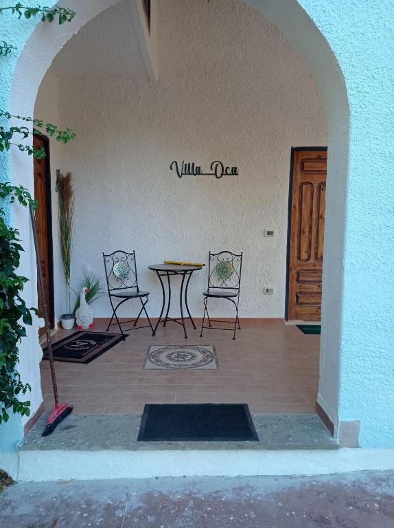 韦莱特里TABERNA ROMANA VILLA OCA b&b的门旁设有带桌椅的天井。