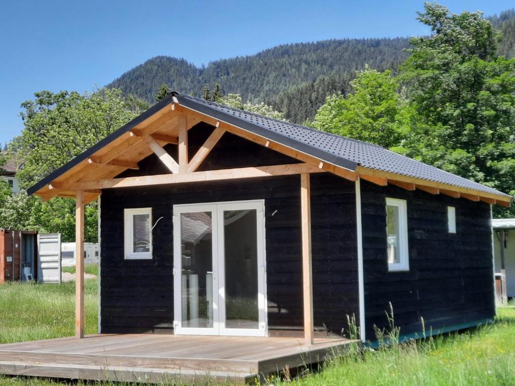 a black tiny house with a gambrel roof at Parc Sonnleiten - Chalet 4 persoons in Gnesau Sonnleiten