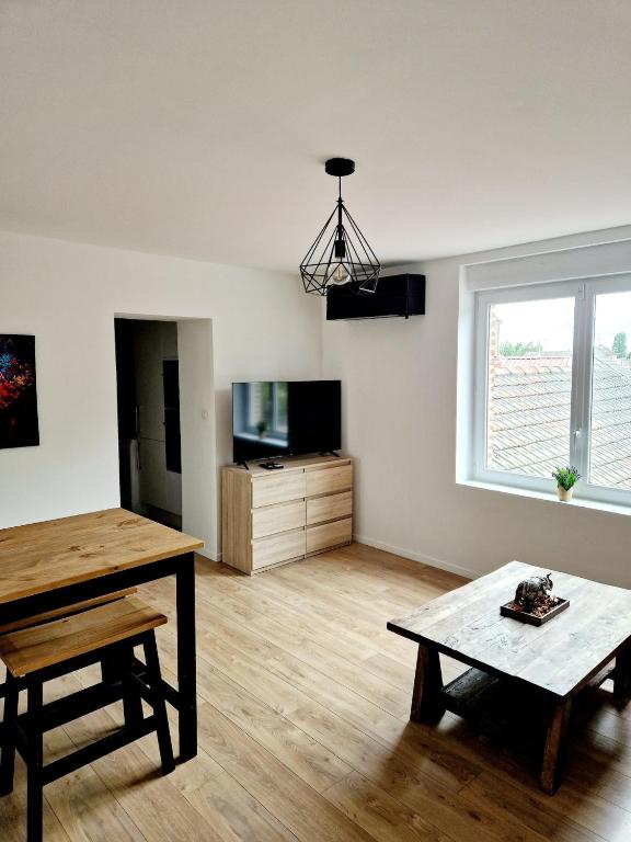 a living room with a table and a coffee table at La Parenthèse Corbehemoise, Stationnement, Wifi in Corbehem
