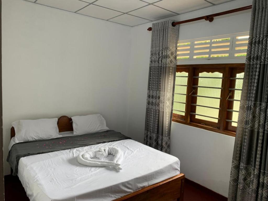 KiriwalagamaFeelATHome STAY - Near sinharajaya的卧室里有一张床，床上放着两条毛巾。