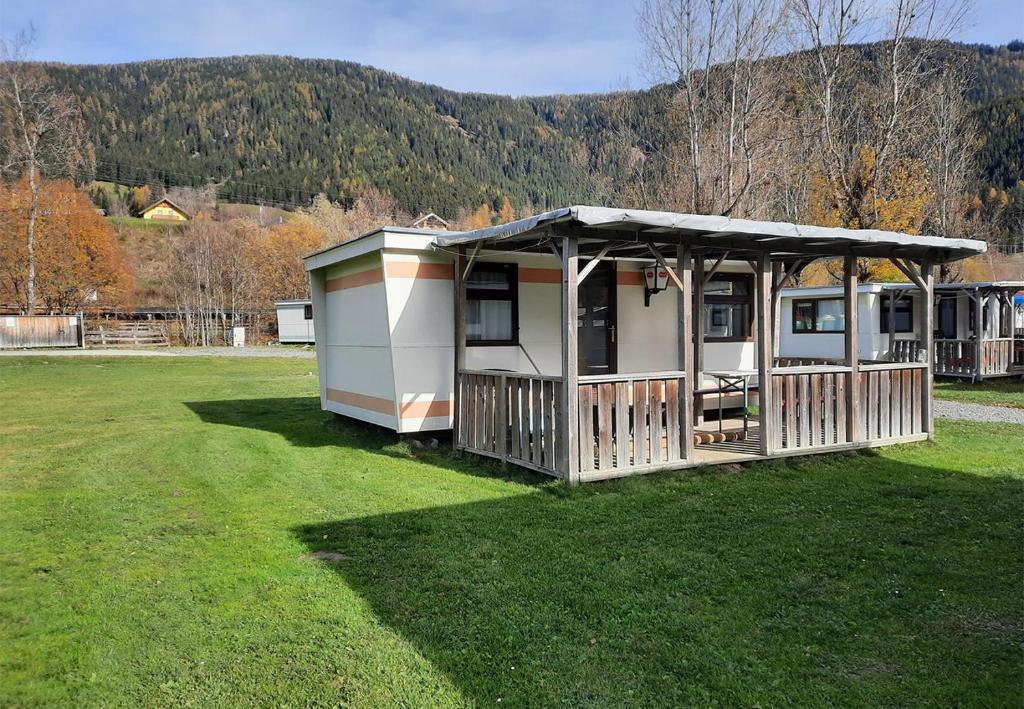 a mobile home with a roof on a grass field at Parc Sonnleiten - Blokhut Basic in Gnesau Sonnleiten