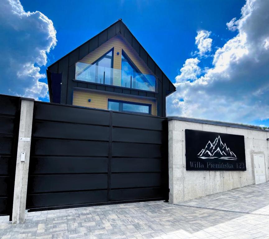 a house behind a garage door with a building at Willa Pienińska 123 in Maniowy